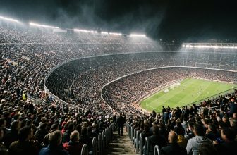 Volle Ränge eines riesigen Flutlichtstadions, von weit oben aus dem Oberrang gesehen