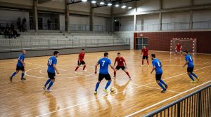 Futsal teams in position on an indoor court during a match, seen from the stand