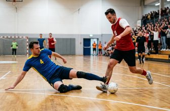 Futsal defender stretched low along the court to block a pass during a match