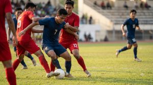 Player shielding the ball in traffic while open space waits beyond